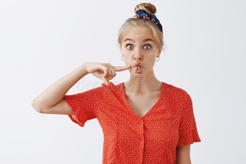 Grappige expressieve aantrekkelijke blonde vrouwelijke student in uitstekende rode stipblouse en hoofdband die mond in vissen vou royalty-vrije stock foto's Grappige expressieve aantrekkelijke blonde vrouwelijke student in uitstekende rode stipblouse en hoofdband die mond in vissen vou royalty-vrije stock foto's