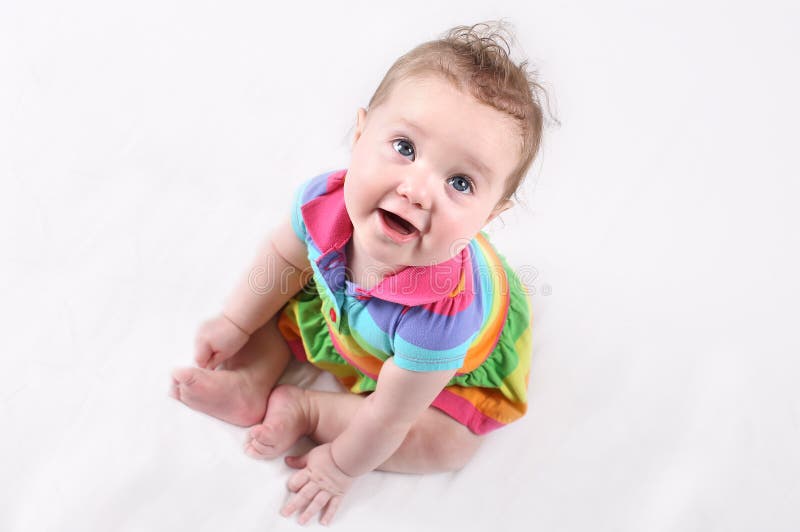 Grappige gelukkige baby in een kleurrijke gestreepte kleding