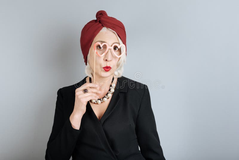 Grappige hogere vrouw die door de hartglazen kijken royalty-vrije stock foto Grappige hogere vrouw die door de hartglazen kijken royalty-vrije stock foto