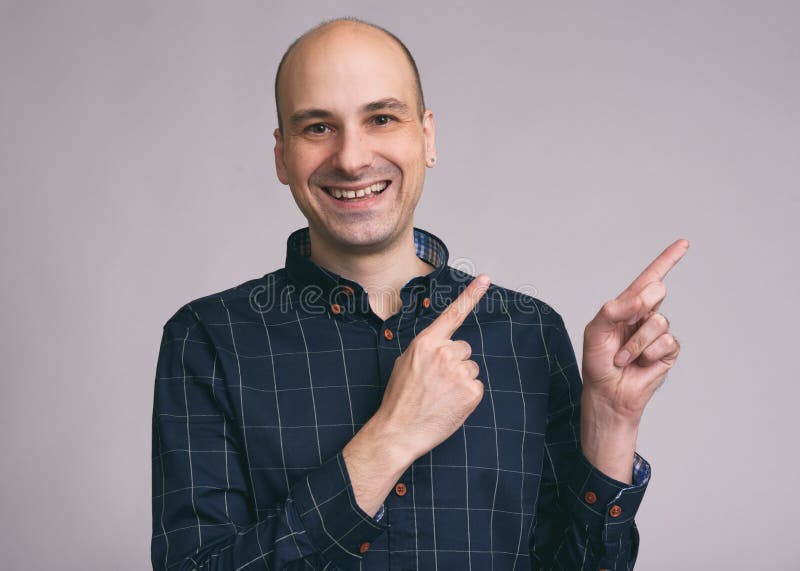 Grappige kale mens die aan exemplaarruimte richten royalty-vrije stock afbeeldingen Grappige kale mens die aan exemplaarruimte richten royalty-vrije stock afbeeldingen