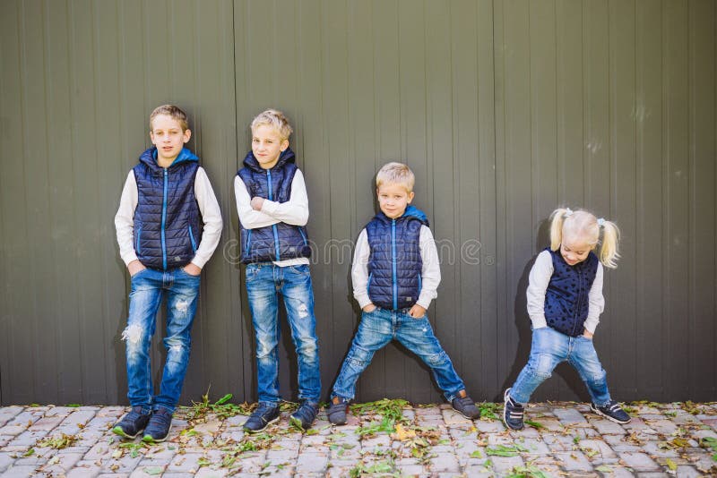 Grappige Kaukasische grote familie van drie broers en zuster stellen die zich op de groeiachtergrond bevinden van muur in de voll royalty-vrije stock afbeeldingen Grappige Kaukasische grote familie van drie broers en zuster stellen die zich op de groeiachtergrond bevinden van muur in de voll royalty-vrije stock afbeeldingen