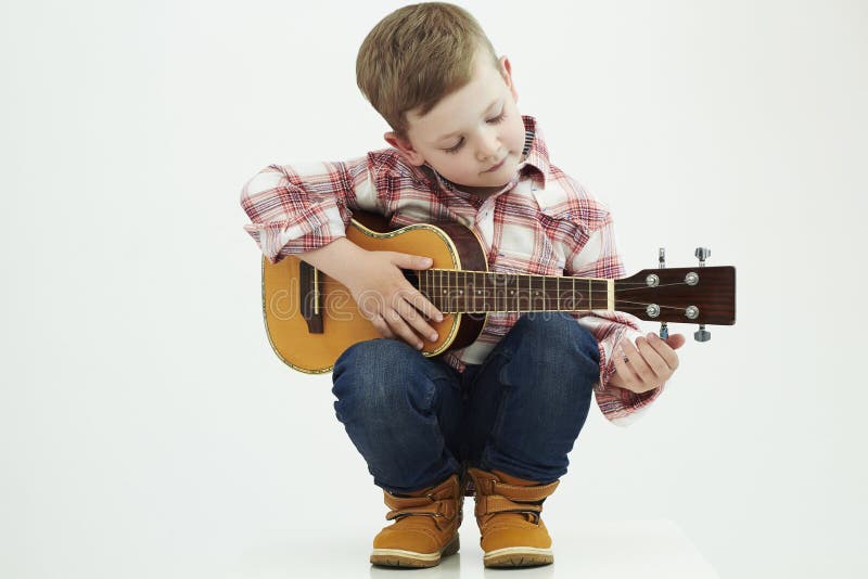 Grappige kindjongen met gitaar de jongens speelmuziek van het land stock afbeelding Grappige kindjongen met gitaar de jongens speelmuziek van het land stock afbeelding