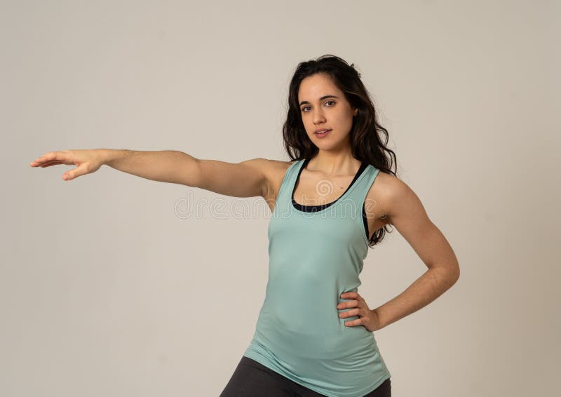 Grappige sportieve mooie donkerbruine vrouw in en gelukkig sportkleren die uitrekken zich stellen stock fotografie Grappige sportieve mooie donkerbruine vrouw in en gelukkig sportkleren die uitrekken zich stellen stock fotografie