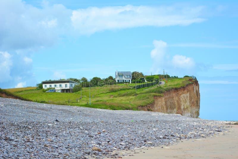 Gras behandelde klip met gebouwen bij strand bij Saint-Aubin-sur-Mer in Normandië Frankrijk royalty-vrije stock foto Gras behandelde klip met gebouwen bij strand bij Saint-Aubin-sur-Mer in Normandië Frankrijk royalty-vrije stock foto