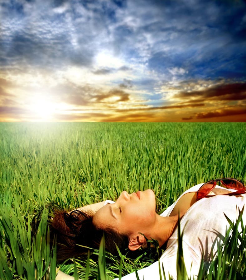 a woman on the grass field and a sunset