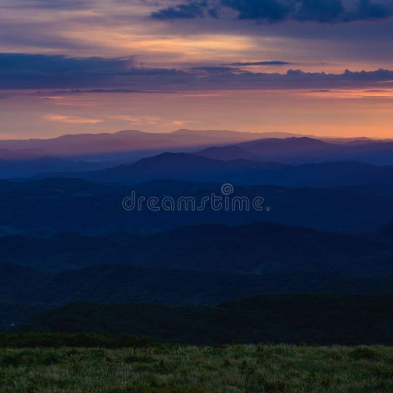 Grassy Field and Layers of Blue Ridge Mountains at sunrise