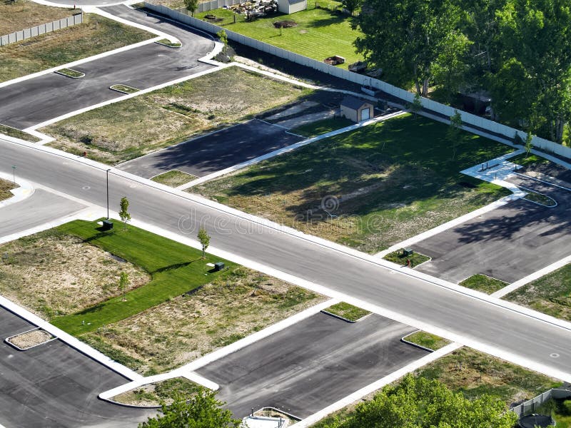 A large patch of land surrounded by trees and grass in the middle of a road stock photos