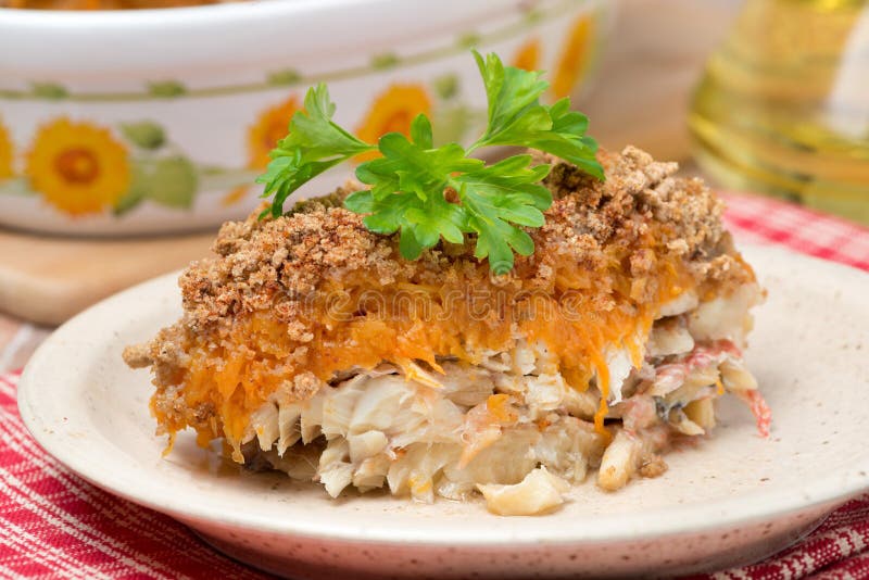 Gratin with fish and pumpkin on a plate, close-up