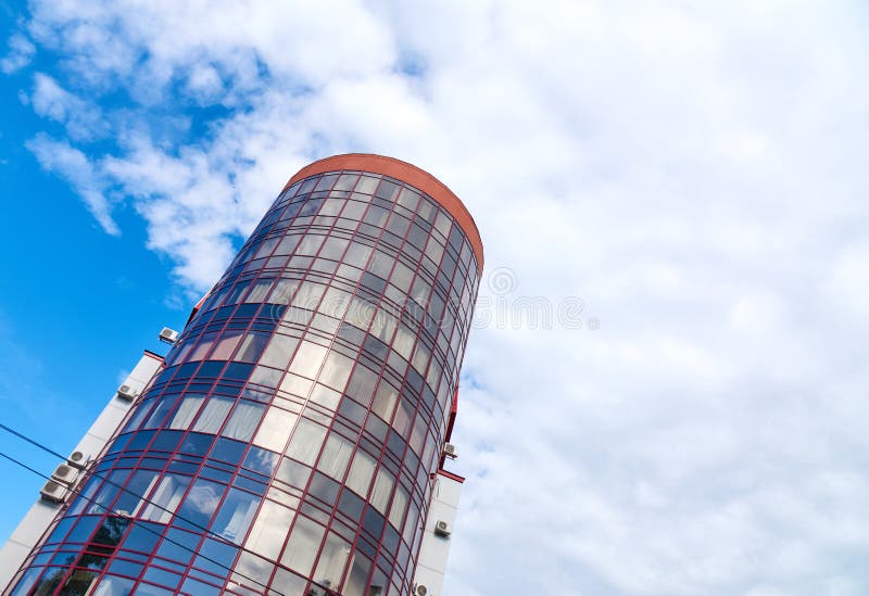 Grattacielo moderno con una forma rotonda unica, fondo del cielo nuvoloso, spazio della copia fotografia stock libera da diritti