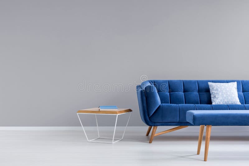 Grauer Raum mit blauer Couch