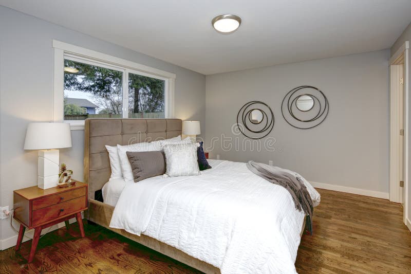 Gray bedroom interior with huge bed, tufted headboard and hardwood floor. Gray bedroom interior with huge bed, tufted headboard and hardwood floor.