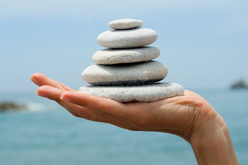 Gravel pile in woman s hands with sea background