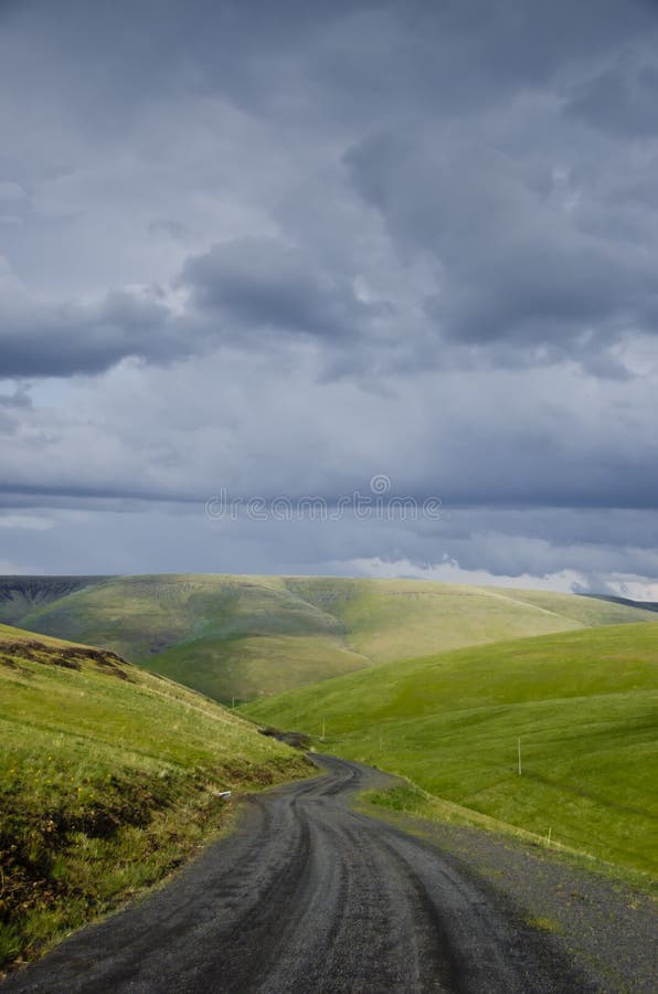 Gravel rural road beneath stormy sky