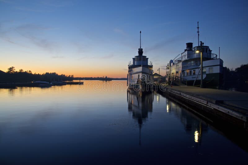 Water reflection of the steamship in the pier at twilight