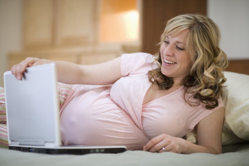 gravid användande kvinna för bärbar dator arkivfoto gravid användande kvinna för bärbar dator arkivfoto
