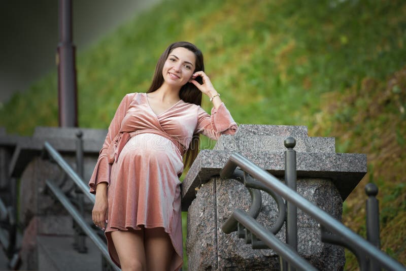 Gravid flicka i en beige klänning Gravid brunettflicka i en beige klänning I f?rv?ntan av ett barn framtida mom royaltyfria bilder Gravid flicka i en beige klänning Gravid brunettflicka i en beige klänning I f?rv?ntan av ett barn framtida mom royaltyfria bilder