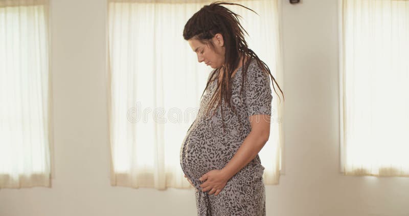 Gravid kvinna med en klänning lager videofilmer