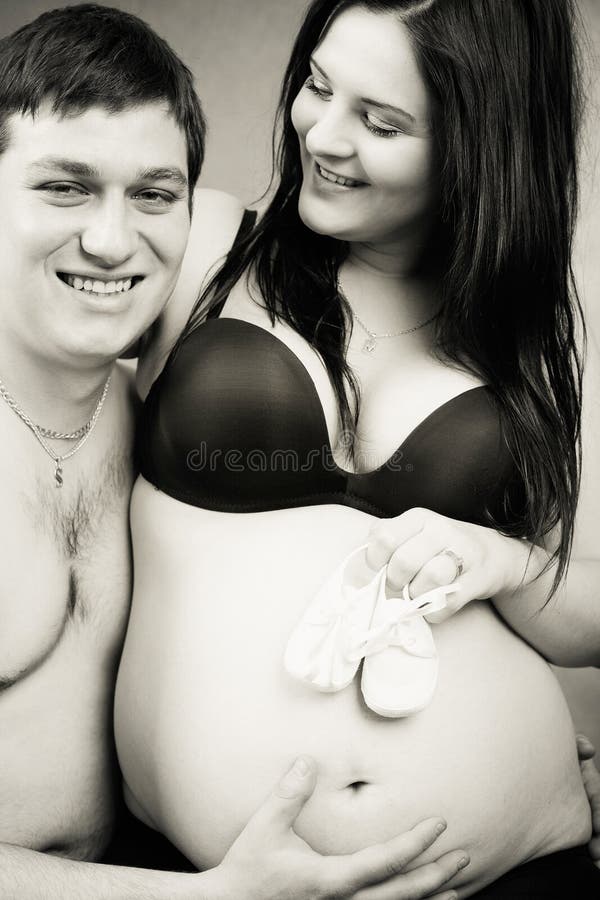 Gravid kvinna med ett barns sko royaltyfri foto Gravid kvinna med ett barns sko royaltyfri foto