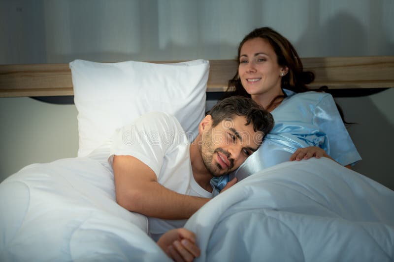 Gravid kvinna med man i sovrummet med en atmosfär av roligt att prata arkivfoto