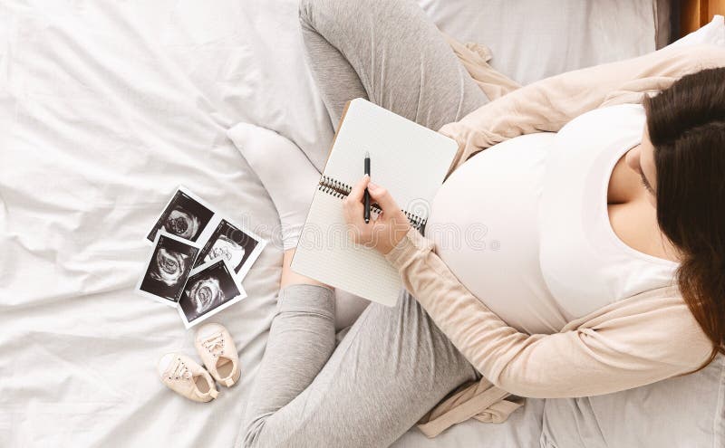 Gravid kvinna som gör emballagelistan för barnbördshus arkivbilder