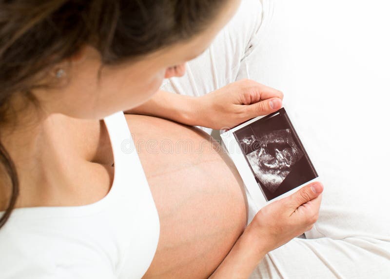 Gravid kvinna som ser, behandla som ett barn bildläsning arkivbild Gravid kvinna som ser, behandla som ett barn bildläsning arkivbild