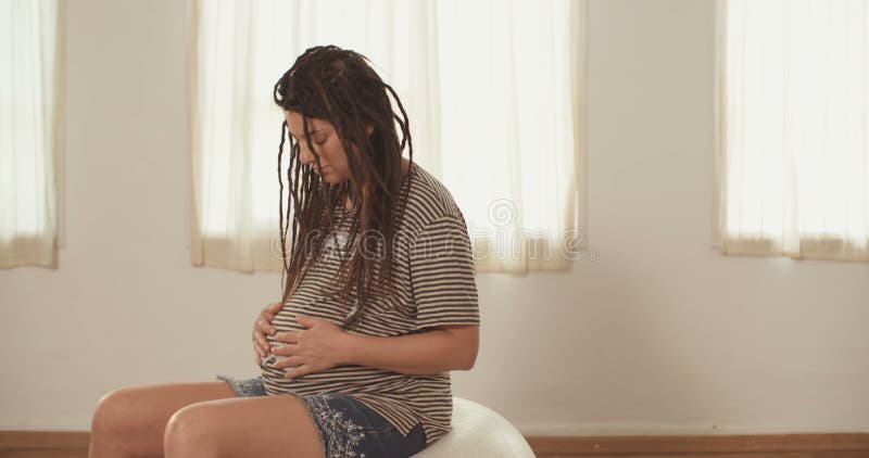 Gravid kvinnasammanträde på en physio boll arkivfilmer