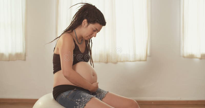 Gravid kvinnasammanträde på en physio boll stock video