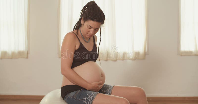 Gravid kvinnasammanträde på en physio boll arkivfilmer