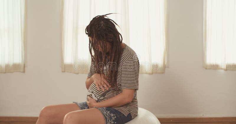 Gravid kvinnasammanträde på en physio boll stock video