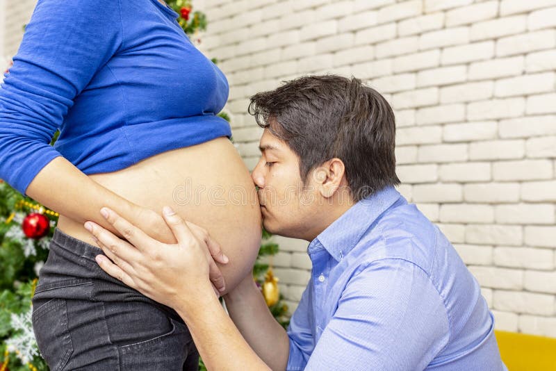 Gravid moder och fader Lycklig ung framtida förälder tillsammans Tycka om för fader och för moder Mamma- och farsaanseende i föns royaltyfria foton Gravid moder och fader Lycklig ung framtida förälder tillsammans Tycka om för fader och för moder Mamma- och farsaanseende i föns royaltyfria foton