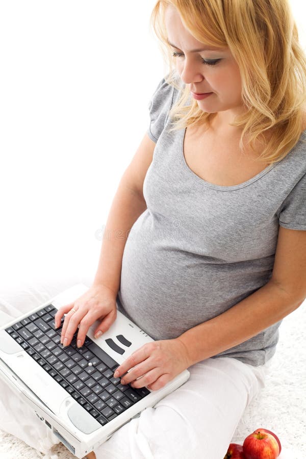 gravid sittande kvinna för golvbärbar dator royaltyfria bilder gravid sittande kvinna för golvbärbar dator royaltyfria bilder