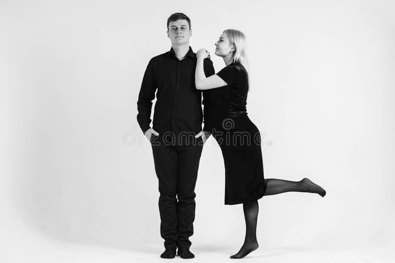 Gravida kvinnor och hennes make som kuddar i svarta kläder på vit bakgrund Svartvit bild Vackert gifta par royaltyfria bilder
