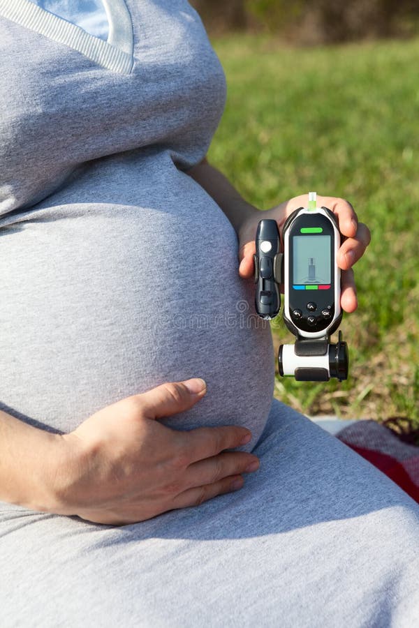 Gravida kvinnor som kontrollerar blodsockernivån med blodglukometer för att förhindra graviditetsdiabetes arkivfoton Gravida kvinnor som kontrollerar blodsockernivån med blodglukometer för att förhindra graviditetsdiabetes arkivfoton