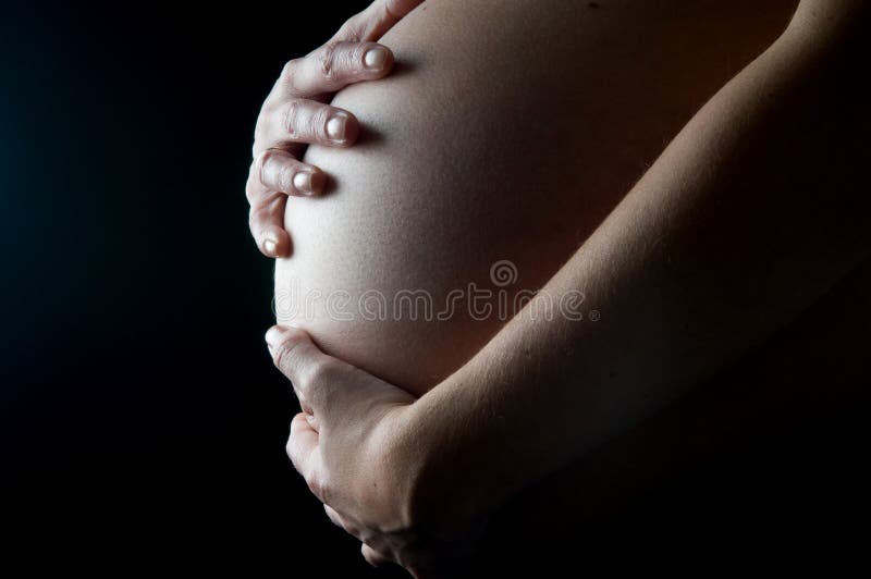 Expecting mother holding her belly, only two weeks to go!. Expecting mother holding her belly, only two weeks to go!