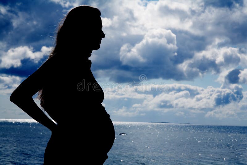 Silhouette of a young pregnant woman at the beach. Silhouette of a young pregnant woman at the beach