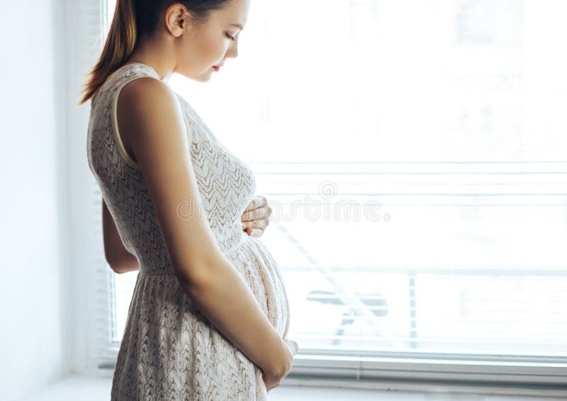 Gravidez, resto, povos e conceito da expectativa - próximo acima da mulher gravida de sorriso feliz que toca em sua barriga em ca fotografia de stock Gravidez, resto, povos e conceito da expectativa - próximo acima da mulher gravida de sorriso feliz que toca em sua barriga em ca fotografia de stock