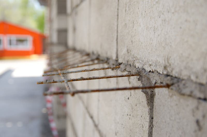 Gray Brick Wall with Iron Bars Reinforcement during Construction Stock