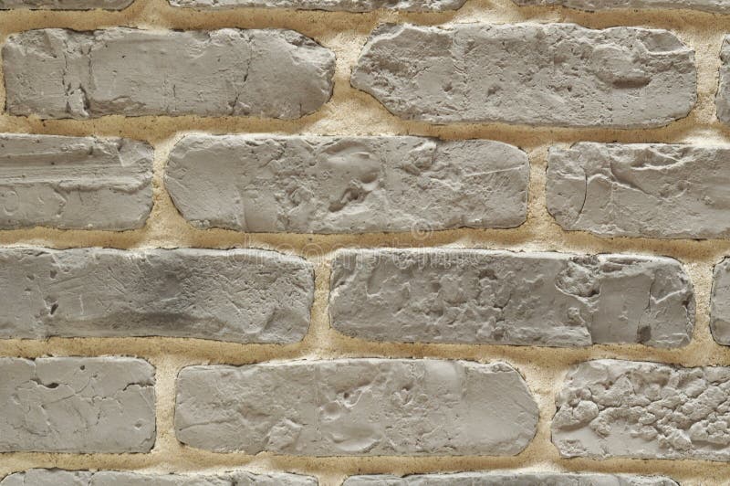 Gray bricks wall with beige cement stock photo