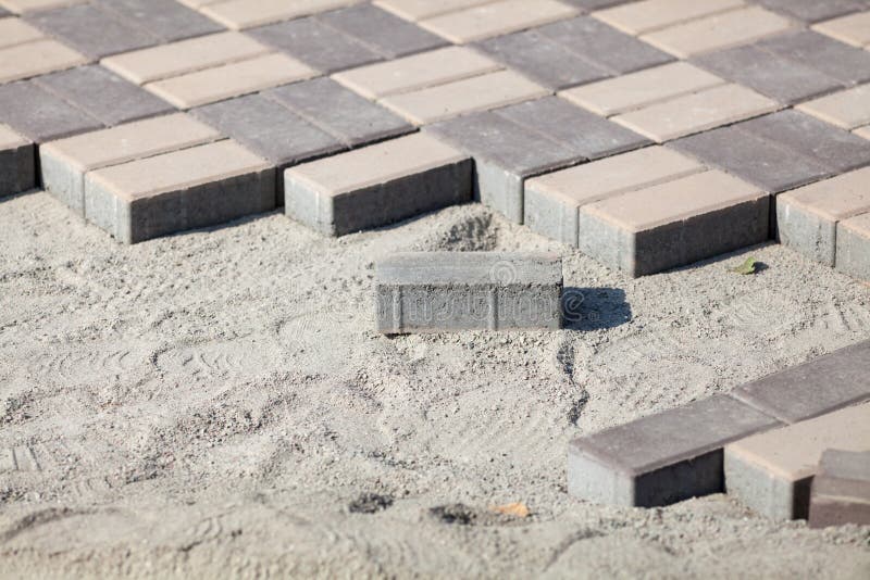 Gray che pavimenta i blocchi - vista laterale Nuovo marciapiede con le pietre rettangolari su zavorra sabbiosa che pavimenta le m fotografia stock libera da diritti Gray che pavimenta i blocchi - vista laterale Nuovo marciapiede con le pietre rettangolari su zavorra sabbiosa che pavimenta le m fotografia stock libera da diritti
