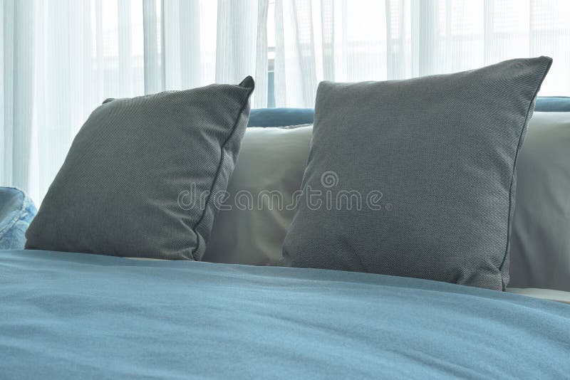 Gray Color Pillows on Bed with Blue Blanket in Modern Bedroom Interior