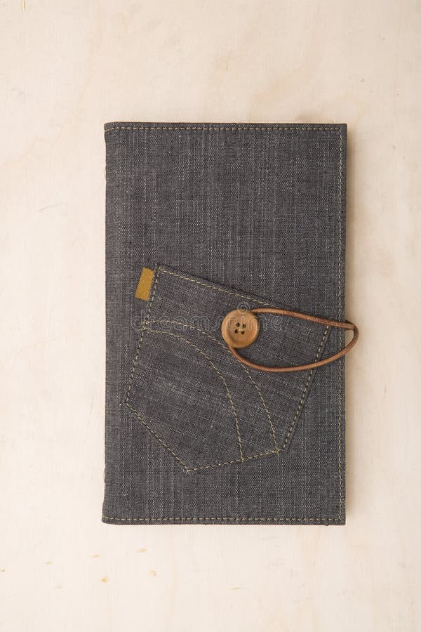 Cover of a gray denim journal note book book photographed directly above sitting on a wood table. Button clasp stock images, royalty-free photos and pictures
