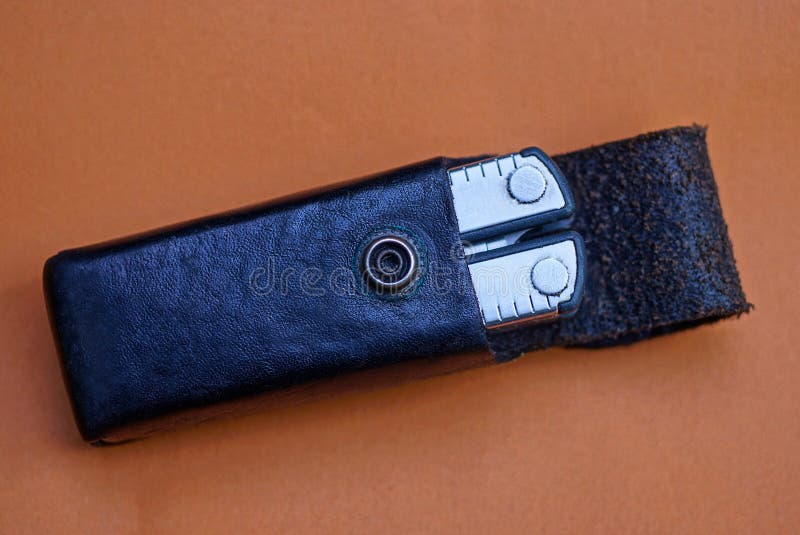 A gray iron multitool in a black leather case royalty free stock photography