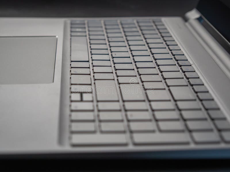 Gray laptop keyboard close up. Low angle view of computer key. Selective soft focus.