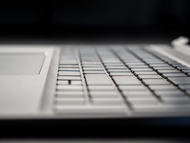 Gray laptop keyboard close up. Low angle view of computer key. Selective soft focus.