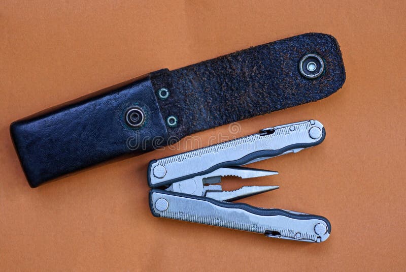 Gray metal multitool and black leather case stock photos