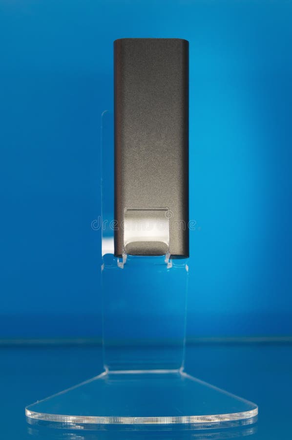 Gray portable USB modem wi-fi adapter on a stand in the showcase blue background royalty free stock image
