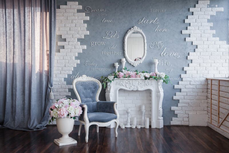 A gray room with a white fireplace and a gray vintage chair, all decorated with peonies and beautiful flowers