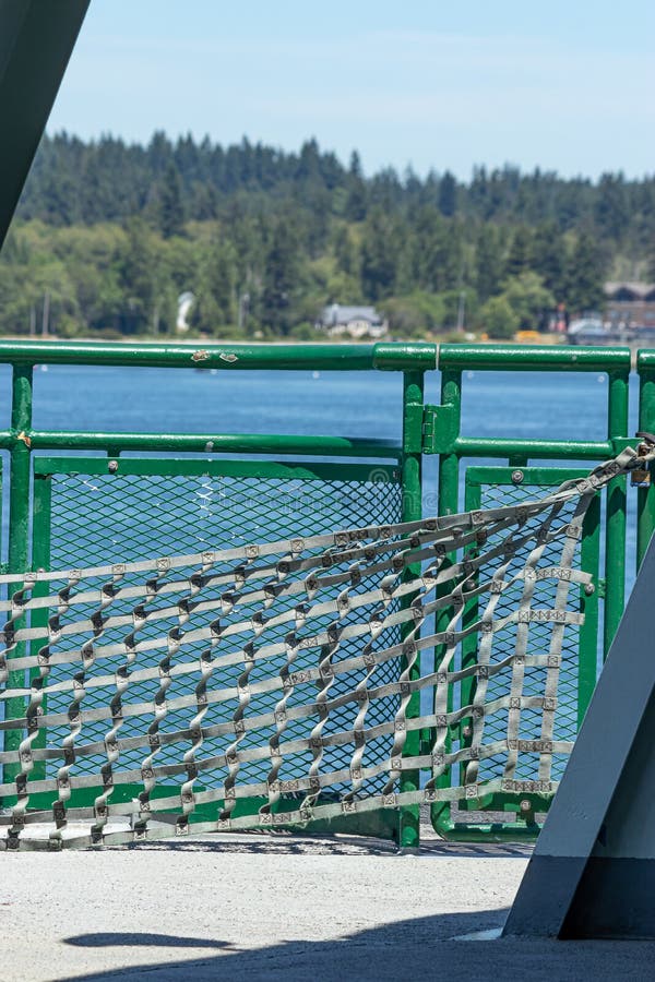 Gray safety netting and green metal railing on side of washington state ferry