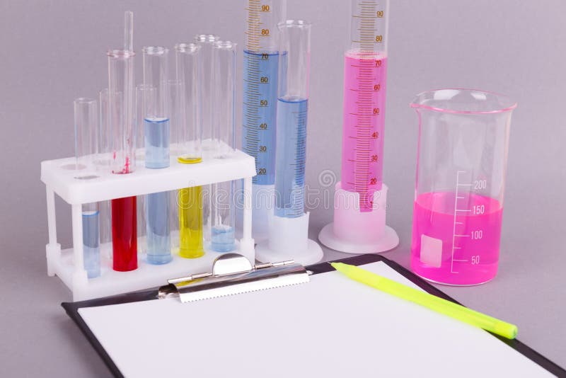 Closeup of test tubes on a gray background, near the tablet with a blank sheet and pen. stock photos Closeup of test tubes on a gray background, near the tablet with a blank sheet and pen. stock photos