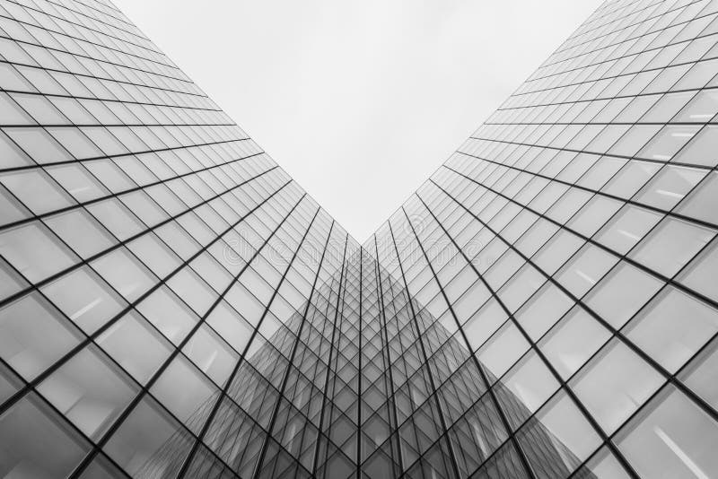 Grayscale Shot of a Modern Building with Glass Walls Stock Image